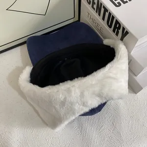 Detail of navy faux suede trapper hat with thick white plush lining for winter warmth