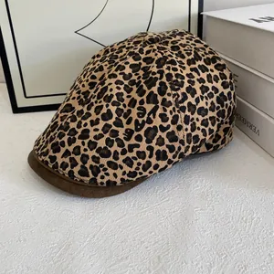 Close-up of leopard print beret with brown suede brim and detailed fabric texture