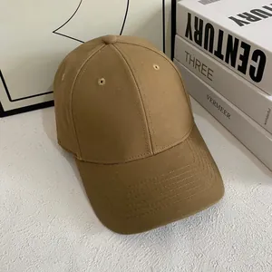 Detalle de gorra de béisbol caqui mostrando costuras, ojales y la visera curva