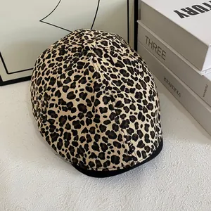 Detailed view of leopard print ivy cap on a minimalist desk with vintage props