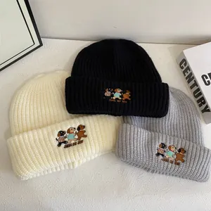 Three embroidered cartoon puppy knit beanies in black, cream and grey colors