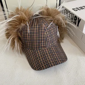Détail du chapeau trappeur à carreaux marron avec fausse fourrure sur fond blanc