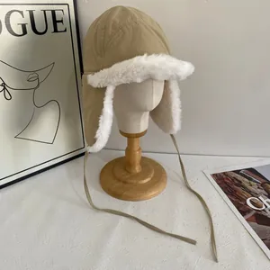 Detail of khaki aviator hat with plush white faux fur lining and chin straps
