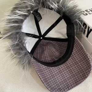 Détail d'un bonnet d'aviateur d'hiver avec tissu à carreaux violet et fausse fourrure