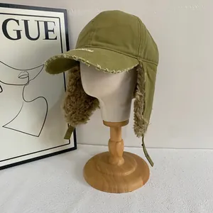 Detail of army green canvas aviator hat with faux shearling lining and embroidery