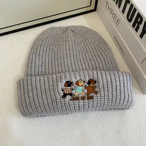 Close-up of cute cartoon dog embroidery and JOIN MY JOY text on grey knitted hat
