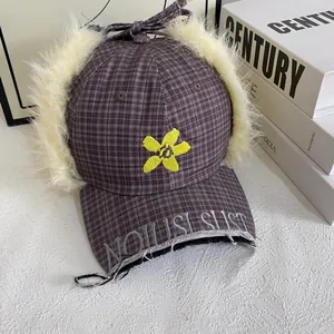 Detail of plaid earflap baseball cap featuring floral embroidery and plush faux fur lining