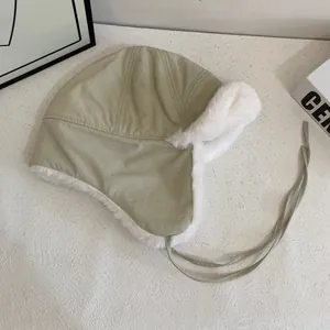 Detail of plush faux fur lining and drawstring on a khaki winter trapper hat