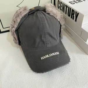 Detail of dark grey pilot baseball cap with faux fur earflaps and embroidery