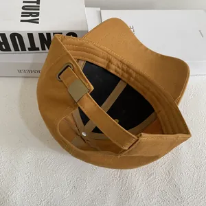 Detalle del interior de la gorra mostaza con banda de sudor y hebilla de metal bronce