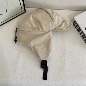 Dettaglio del cappello aviatore beige con fodera in pile e cinturino regolabile con fibbia