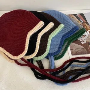 Detailaufnahme bunter gerippter Strickmützen mit Ohrenschutz und Bindebändern