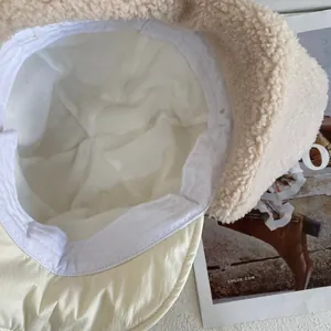 Dettaglio del cappello invernale in sherpa color crema con fodera e consistenza