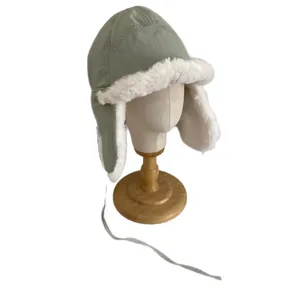 Winter thermal earflap aviator hat in sage green with white faux fur lining and chin straps