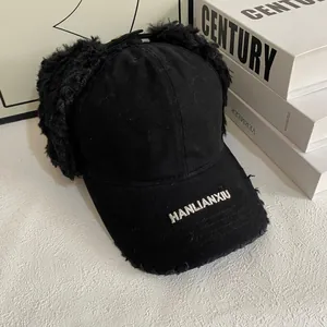 Detail of black canvas baseball hat with plush earflaps and white HANLIANXIU embroidery