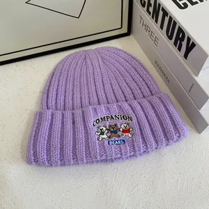 Detalle del gorro de punto violeta claro con bordado de tres ositos muy bonitos