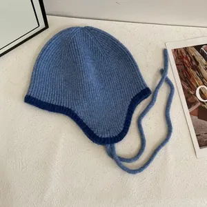 Detailierte Strickstruktur der blauen winddichten Mütze mit Ohrenklappen