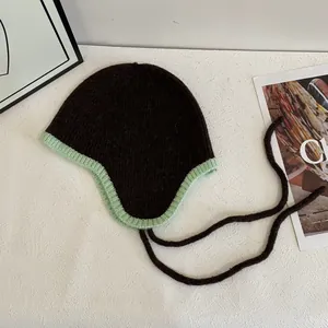 Nahaufnahme der Kontrast-Strickmütze mit Ohrenklappen, dicker Wolle und Bindebändern