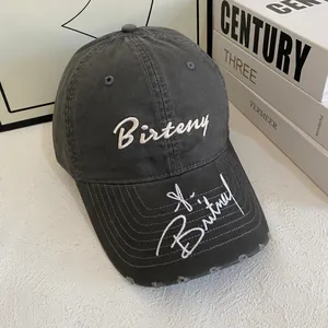Close-up of vintage grey cotton baseball cap with white Birteny embroidery and distressed brim