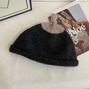 Detail of two-tone knit beanie with soft grey and lavender textures on stylish background