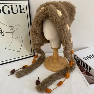 Detail van de zachte imitatiebont textuur en kleurrijke pompons op de winterse oorflapmuts