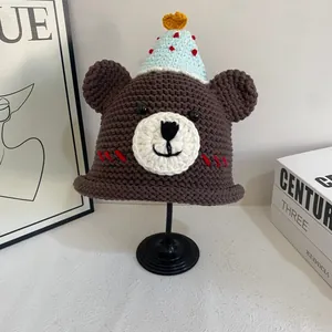 Detailed macro view of handmade brown crochet bear hat with mini party cone topper
