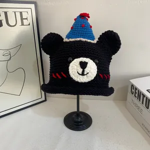 Handmade black bear knit beanie with blue party hat and ears on display stand