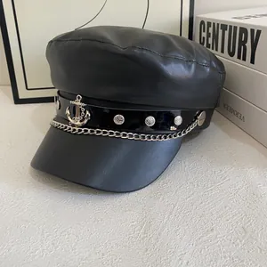 Detail of black PU leather baker boy hat with silver anchor emblem and chain