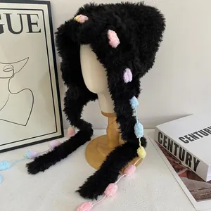 Detailopname van zwarte pluche muts met kleurrijke pastelkleurige pompons van bont