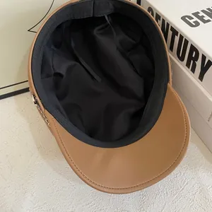 Detail view of brown PU leather newsboy cap with inner lining and adjustable drawstring