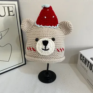 Detailed close-up of a handmade bear knit hat with a festive red pointed cap and soft texture