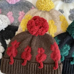Texture a maglia dettagliata e pompon soffice su berretti invernali motivo gatto