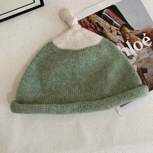 Cute Japanese style contrast color knitted beanie with top knot detail for winter