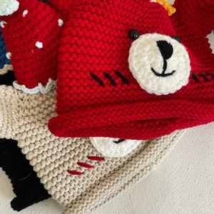 Detail of handmade bear-shaped knit hats showing thick wool texture and cute ear designs