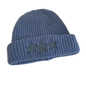 Gorro de punto acanalado azul marino con tres parches de estrellas de cuero