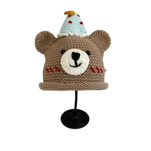 Cute bear-shaped knit hat for kids with party cap detail on a clean white background