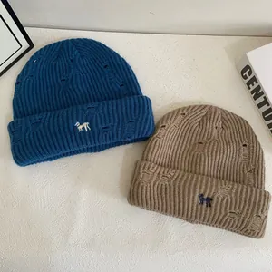 Distressed knit beanies in navy and khaki with small animal embroidery and thick texture