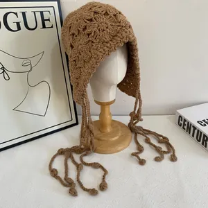 Bonnet en tricot marron fait main avec motifs floraux, cache-oreilles et glands longs