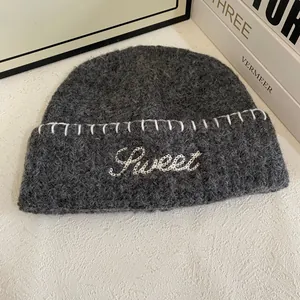 Detailed close-up of dark grey mohair beanie featuring white Sweet letter embroidery