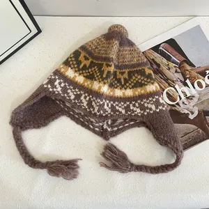 Dettaglio di un cappello in maglia Fair Isle viola con paraorecchie e motivi festivi