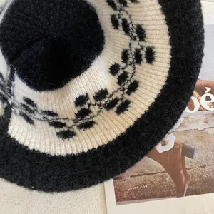 Dettaglio ravvicinato del cappello in maglia spessa con motivo jacquard bianco e nero