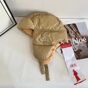 Dettaglio del cappello da pilota kaki con fodera in pile e etichetta di manutenzione