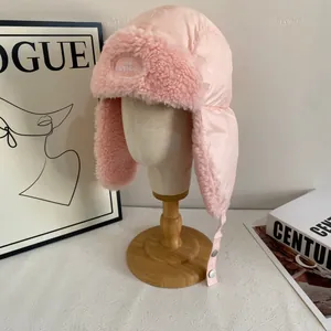 Detailed close-up of pink plush trapper hat with soft faux fur lining and buckle strap