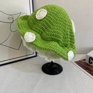Dettaglio cappello a fungo verde in maglia con pois bianchi e tesa ondulata