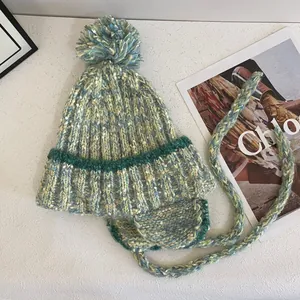 Winter mixed-color knit beanie with pompom, ear flaps and braided ties for women