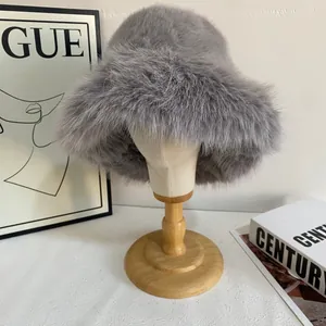 Close-up of plush grey faux fox fur bucket hat showing thick texture on a wooden stand