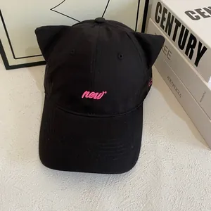 Close-up of black baseball cap with cute cat ears and pink 'new' embroidery detail