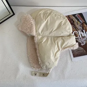 Close-up of beige aviator hat with soft faux fur lining and adjustable buckle strap