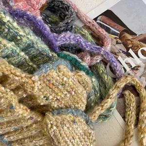 Detailed texture of thick knit colorful beanies in pink, purple and mixed green yarn