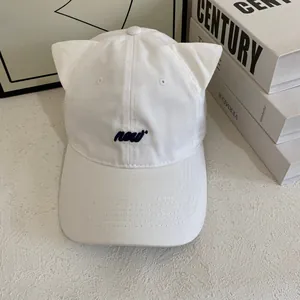 Close-up of white canvas baseball cap with cute cat ears and blue new embroidery